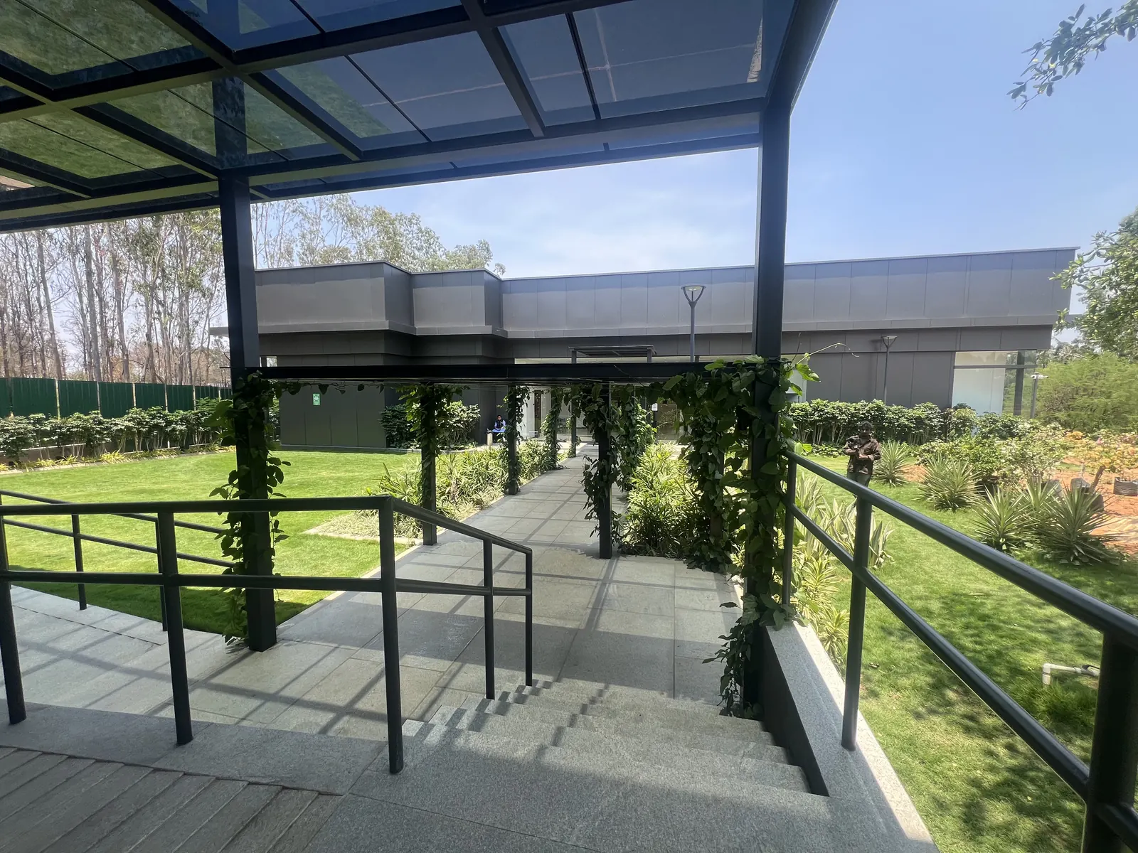 Featured Image of Godrej Vanantara Experience Centre outdoor steps and pergola overlooking the manicured lawn