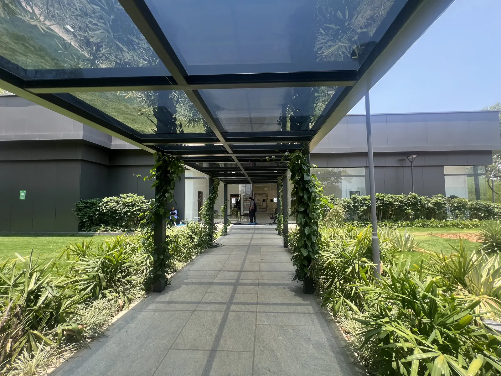 Featured Image of Godrej Vanantara Experience Centre landscaped pergola walkway leading to the main entrance